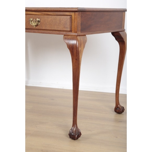 18 - A MAHOGANY DESK

with tooled leather top and two central drawers, the cabriole legs terminating on c... 