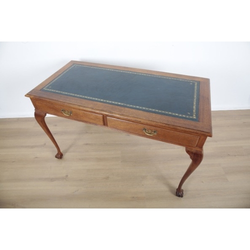 18 - A MAHOGANY DESK

with tooled leather top and two central drawers, the cabriole legs terminating on c... 