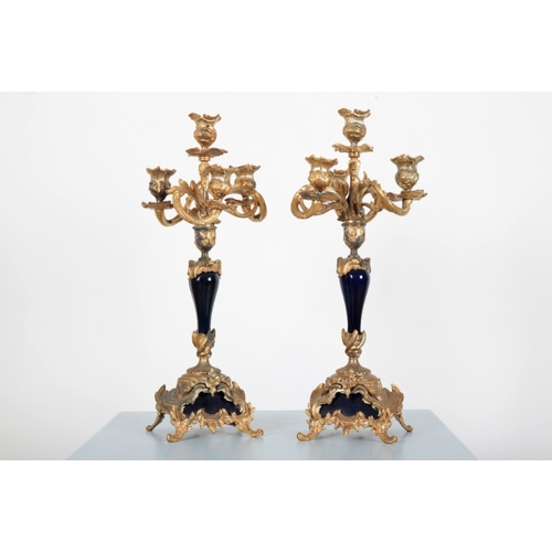 41 - A FRENCH GILT METAL MOUNTED BLUE PORCELAIN CLOCK GARNITURE

in the Rococo style, the clock surmounte... 