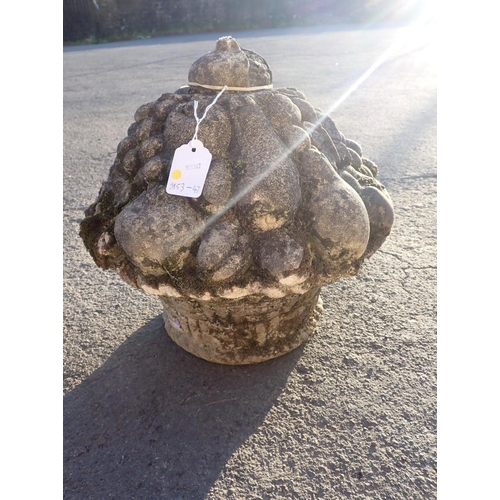 11 - A CAST GARDEN ORNAMENT

modelled as a basket of fruit, topped by a pomegranate, 30cm high approx