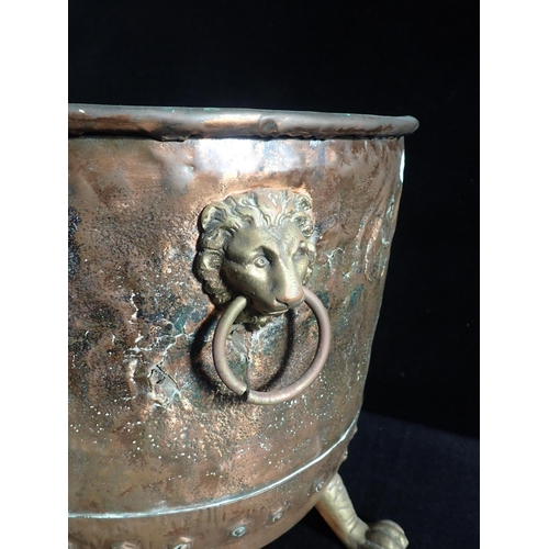 119 - A RIVETTED COPPER LOG OR COAL BIN

with lion mask handles and claw feet, 38 cms high