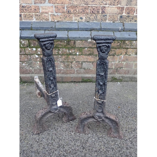 141 - A LARGE PAIR OF COUNTRY HOUSE IRON FIRE DOGS

cast with grotesque heads, possibly late 17th century,... 