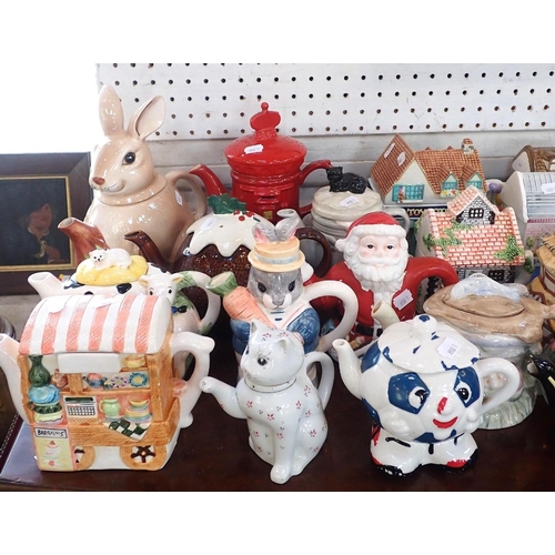 46 - A COLLECTION OF NOVELTY CERAMIC TEAPOTS

many in the form of houses, shops and other domestic buildi... 