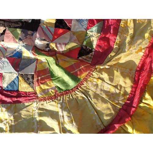 98 - AN ANTIQUE PATCHWORK BED COVER

made with brightly patterned silks and cottons 267 x 245cm (lacking ... 