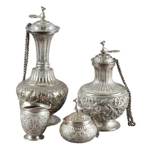 529 - THREE INDIAN WHITE METAL LIDDED VESSELS

each with bird finials, with reeded necks and embossed thro... 