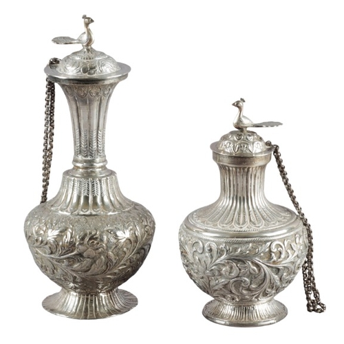 529 - THREE INDIAN WHITE METAL LIDDED VESSELS

each with bird finials, with reeded necks and embossed thro... 