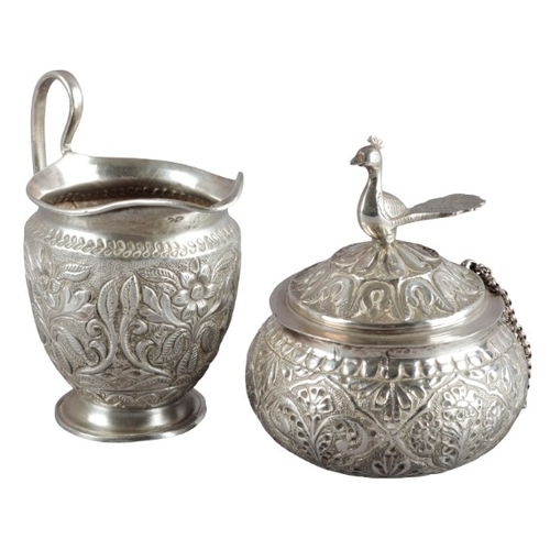 529 - THREE INDIAN WHITE METAL LIDDED VESSELS

each with bird finials, with reeded necks and embossed thro... 