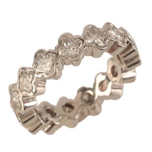 68 - A DIAMOND ETERNITY RING

in 18ct white gold, set throughout with fancy cut diamonds held in quatrefo... 