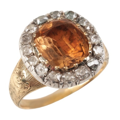 74 - AN ANTIQUE GEORGIAN IMPERIAL TOPAZ AND DIAMOND CLUSTER RING

in silver on 15ct gold, set with a cush... 