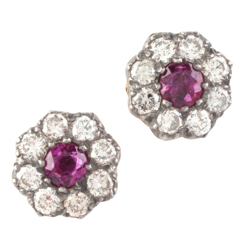 97 - A PAIR OF RUBY AND DIAMOND CLUSTER STUD EARRINGS

in silver on gold, each set with a round cut ruby,... 