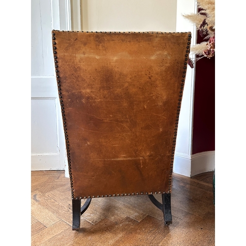 25 - A MAHOGANY WINGBACK ARMCHAIR

stamped '34544' to a back leg, with distressed leather covers, on shor... 