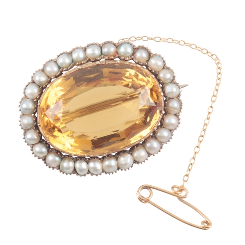 152 - A CITRINE AND SEED PEARL BROOCH

set in unmarked yellow metal, with attached safety chain, c. 32mm w... 
