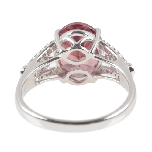 93 - AN 18CT WHITE GOLD ZIRCON AND DIAMOND RING

the oval mixed cut zircon, c. 11mm x 9mm x 5.5mm, four c... 