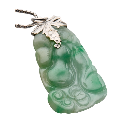 134 - A JADE PENDANT NECKLACE the carved jade pendant, with a white metal foliage suspension, attached to ... 