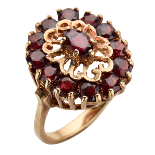 174 - A 1970'S 9CT GOLD GARNET CLUSTER RING the oval mixed cut garnet claw set in pierced setting surround... 