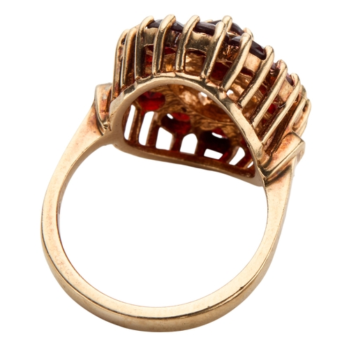 174 - A 1970'S 9CT GOLD GARNET CLUSTER RING the oval mixed cut garnet claw set in pierced setting surround... 