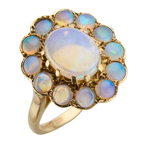 177 - A 9CT YELLOW GOLD ETHIOPIAN OPAL CLUSTER RING the oval central cabochon surrounded by twelve round c... 
