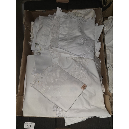 433 - A large collection of vintage white and off-white linens including lace-trimmed tablecloths and embr... 