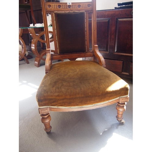 90 - An antique mahogany low bedroom chair with carved floral detailing to back, dark green velvet uphols... 