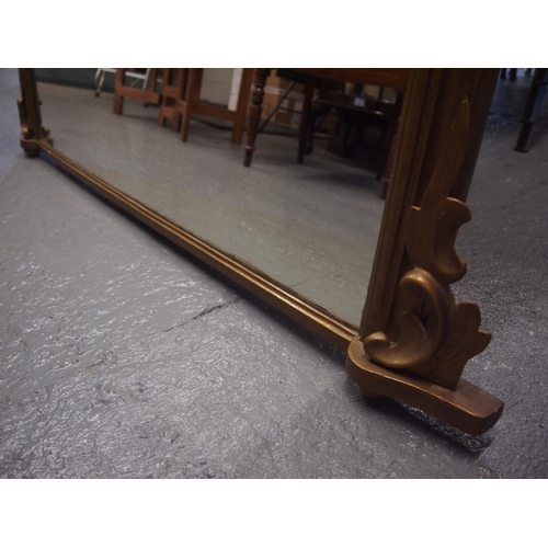 97 - An antique giltwood framed oval mantle mirror with hand carved scroll leaf design detailing