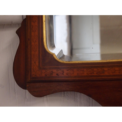 61 - An antique Georgian mahogany wall mirror. The bevelled rectangular glass sits in a moulded frame inl... 