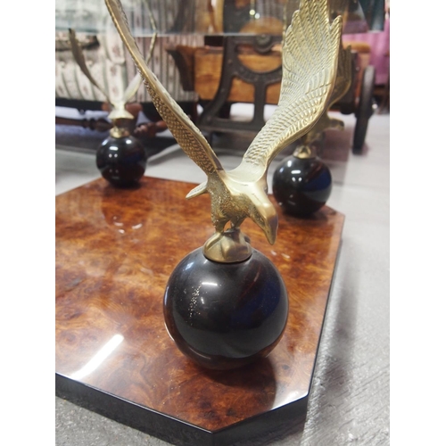 87 - A bevelled glass top square table with burr walnut design to base with Eagle perched on ball pedesta... 