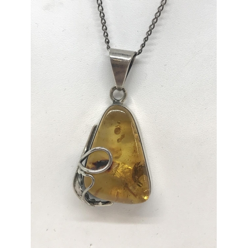 27 - An art nouveau style silver and amber pendant with silver chain, both stamped 925, approx. length of... 