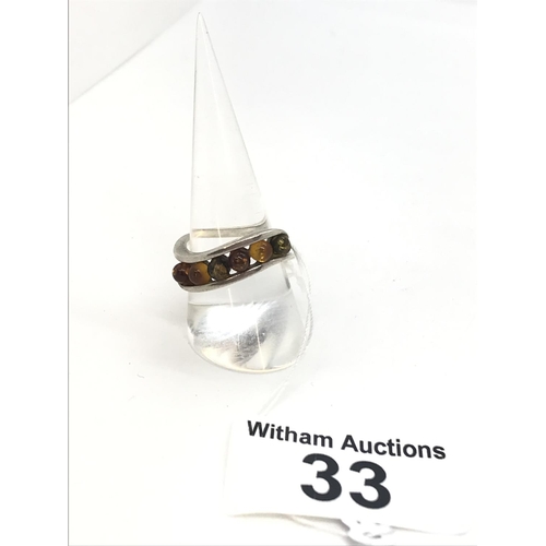 33 - A silver and amber ring with five stones inset to the twist design band, approx. size Q