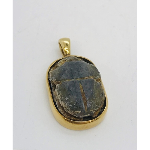 72 - Egyptian scarab beetle set into 22kt gold pendant, stamped 750, approx. overall length 2cm