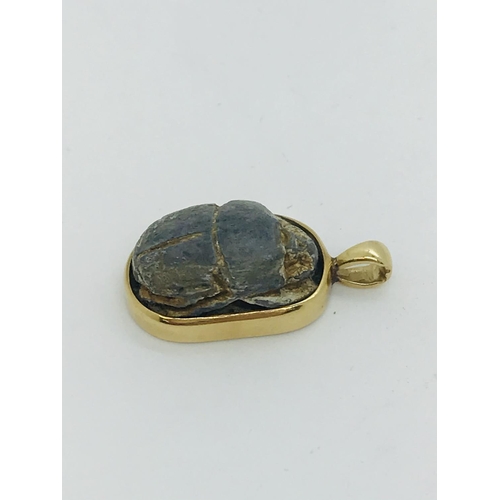 72 - Egyptian scarab beetle set into 22kt gold pendant, stamped 750, approx. overall length 2cm