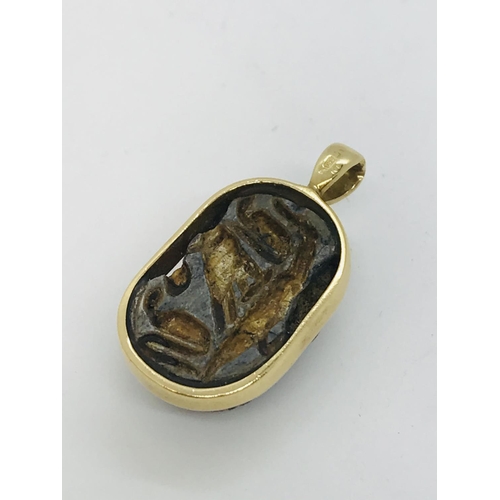 72 - Egyptian scarab beetle set into 22kt gold pendant, stamped 750, approx. overall length 2cm