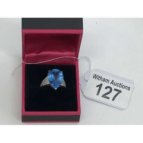 127 - A white gold blue topaz pear shaped ring with diamonds to the mount, unmarked, approx. size M