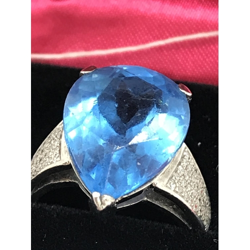 127 - A white gold blue topaz pear shaped ring with diamonds to the mount, unmarked, approx. size M