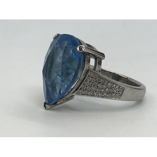 127 - A white gold blue topaz pear shaped ring with diamonds to the mount, unmarked, approx. size M