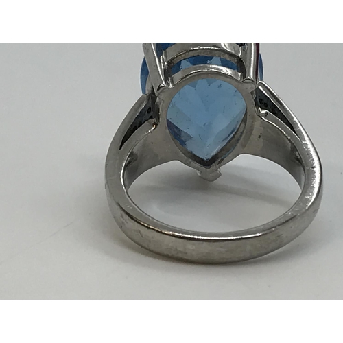 127 - A white gold blue topaz pear shaped ring with diamonds to the mount, unmarked, approx. size M