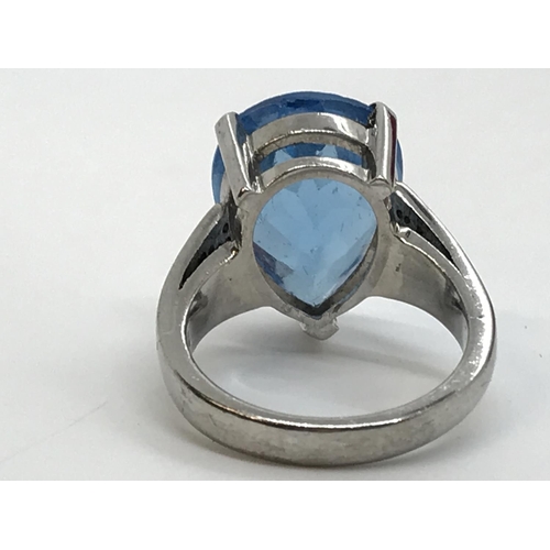 127 - A white gold blue topaz pear shaped ring with diamonds to the mount, unmarked, approx. size M