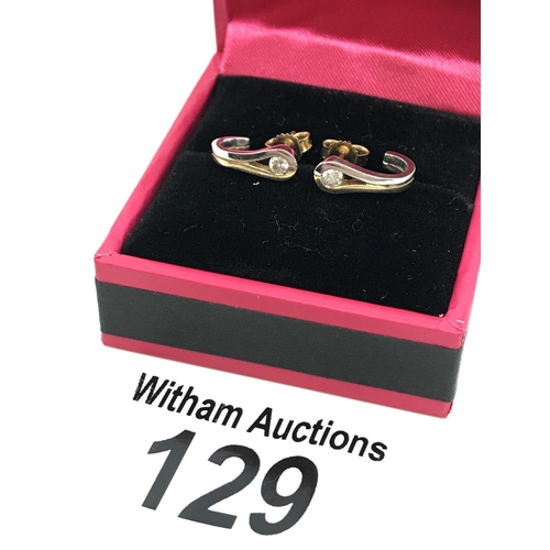 129 - A pair of mixed gold and diamond half hoop earrings, 14ct stamped to butterfly