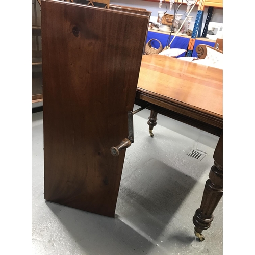 76a - Antique mahogany extendable table with decorate turned legs on castors, with winder