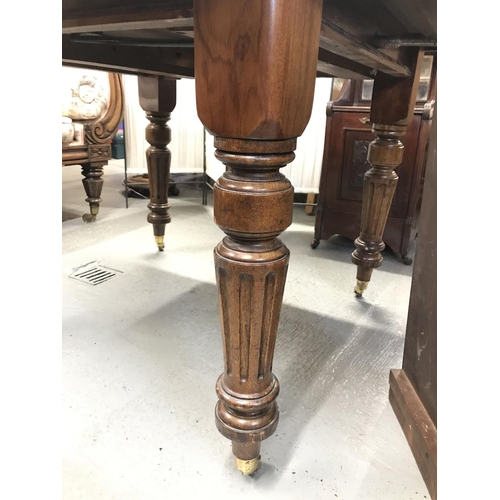 76a - Antique mahogany extendable table with decorate turned legs on castors, with winder