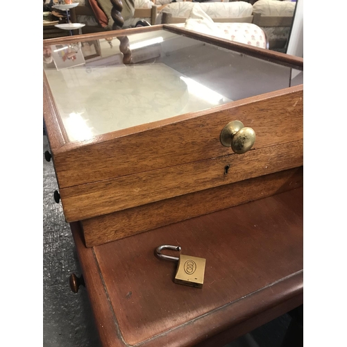 83 - An oak and glass display case with brass handle to side for top opening complete with padlock and ke... 