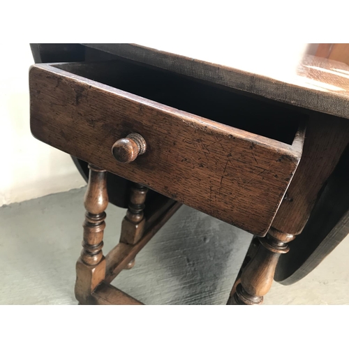 90 - A solid oak drop leaf gate leg table and x4 Windsor style wheelback chairs (of which 2 are carvers),... 