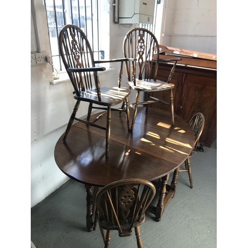 90 - A solid oak drop leaf gate leg table and x4 Windsor style wheelback chairs (of which 2 are carvers),... 