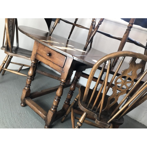 90 - A solid oak drop leaf gate leg table and x4 Windsor style wheelback chairs (of which 2 are carvers),... 