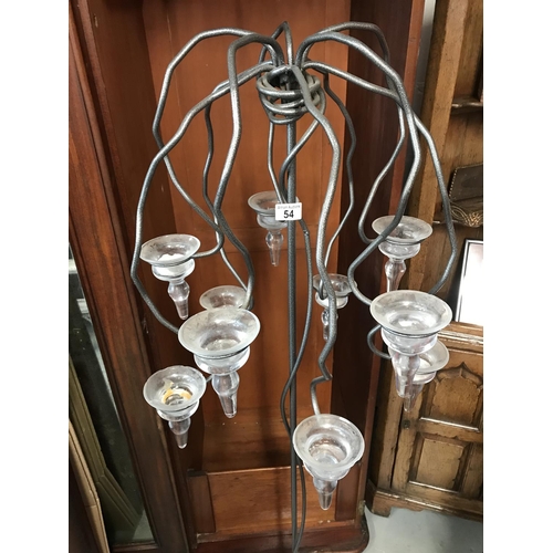 54 - A quirky floor standing metal candelabra with glass volatile candle holders, very heavy, approx. hei... 