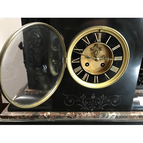 62 - A large Victorian black slate and marble mantle clock with cherub and Grecian design to facades, com... 