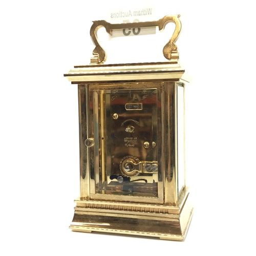 65 - A brass cased carriage clock with key, 11 Jewel, English movement with white dial and Roman numerals... 