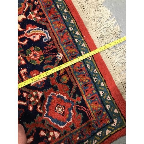 82 - A large rectangular rug with cotton fringe trim of Persian design, approx. size L290cm x W 205cm