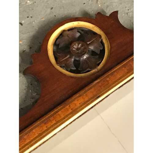 121 - An antique Georgian mahogany wall mirror. The bevelled rectangular glass sits in a moulded frame inl... 