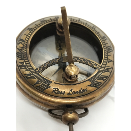 208 - A brass sundial and compass, stamped Ross London