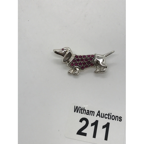 211 - A silver dachshund brooch, set with rubies stamped sterling